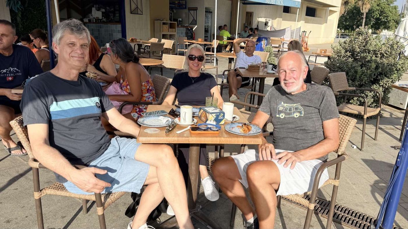 Friends sharing drinks at an outdoor table in Málaga